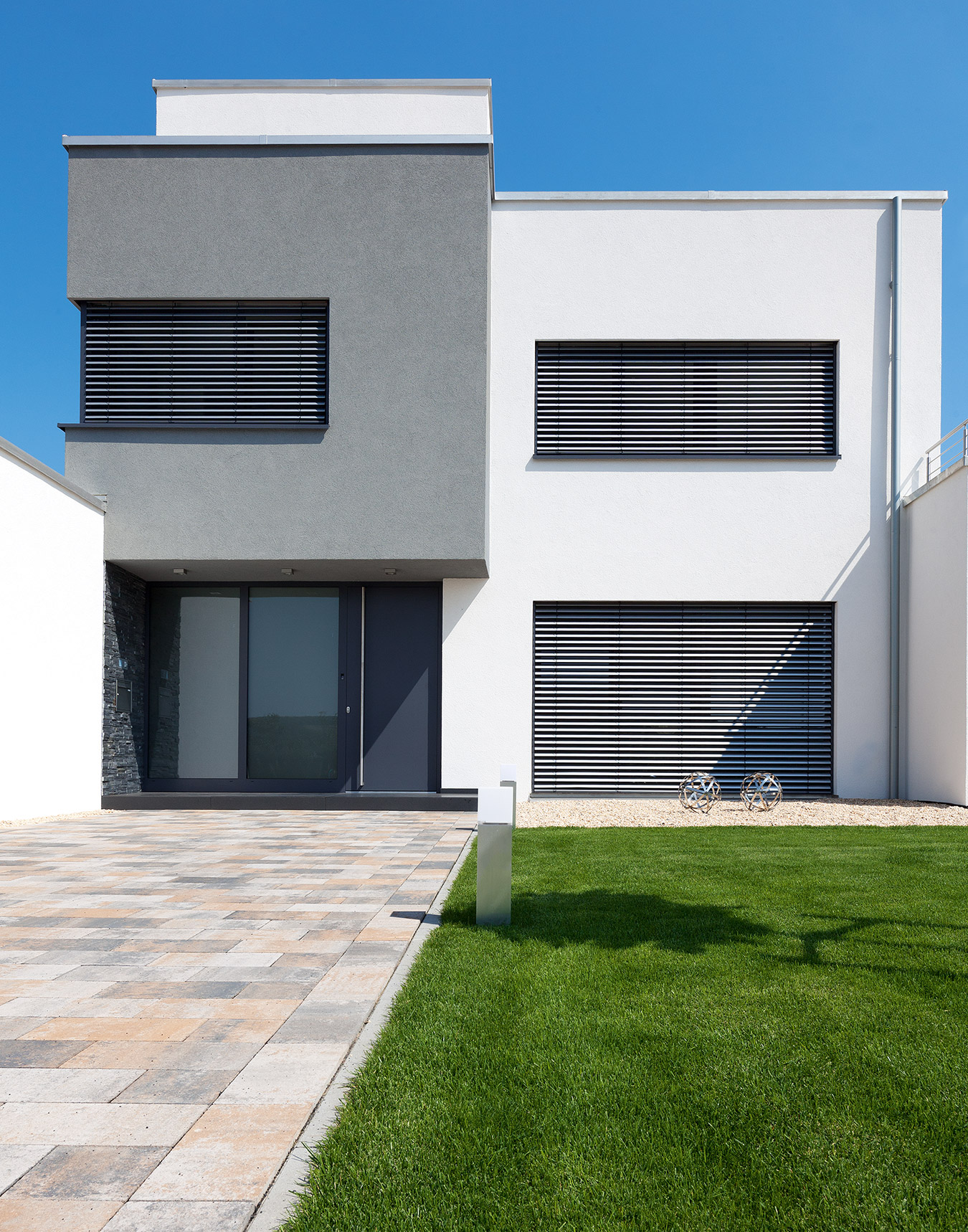 Runtergefahrene Raffstoren für Pforzheim an einem modernen Wohnhaus mit Flachdach im Sonnenlicht